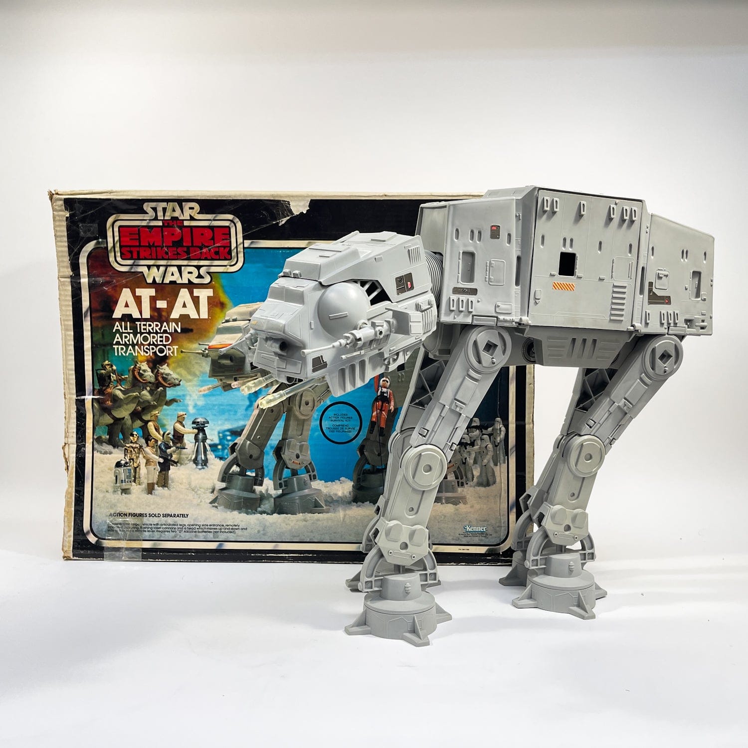 A complete vintage Kenner Star Wars AT-AT posed beside its original Empire Strikes Back box.